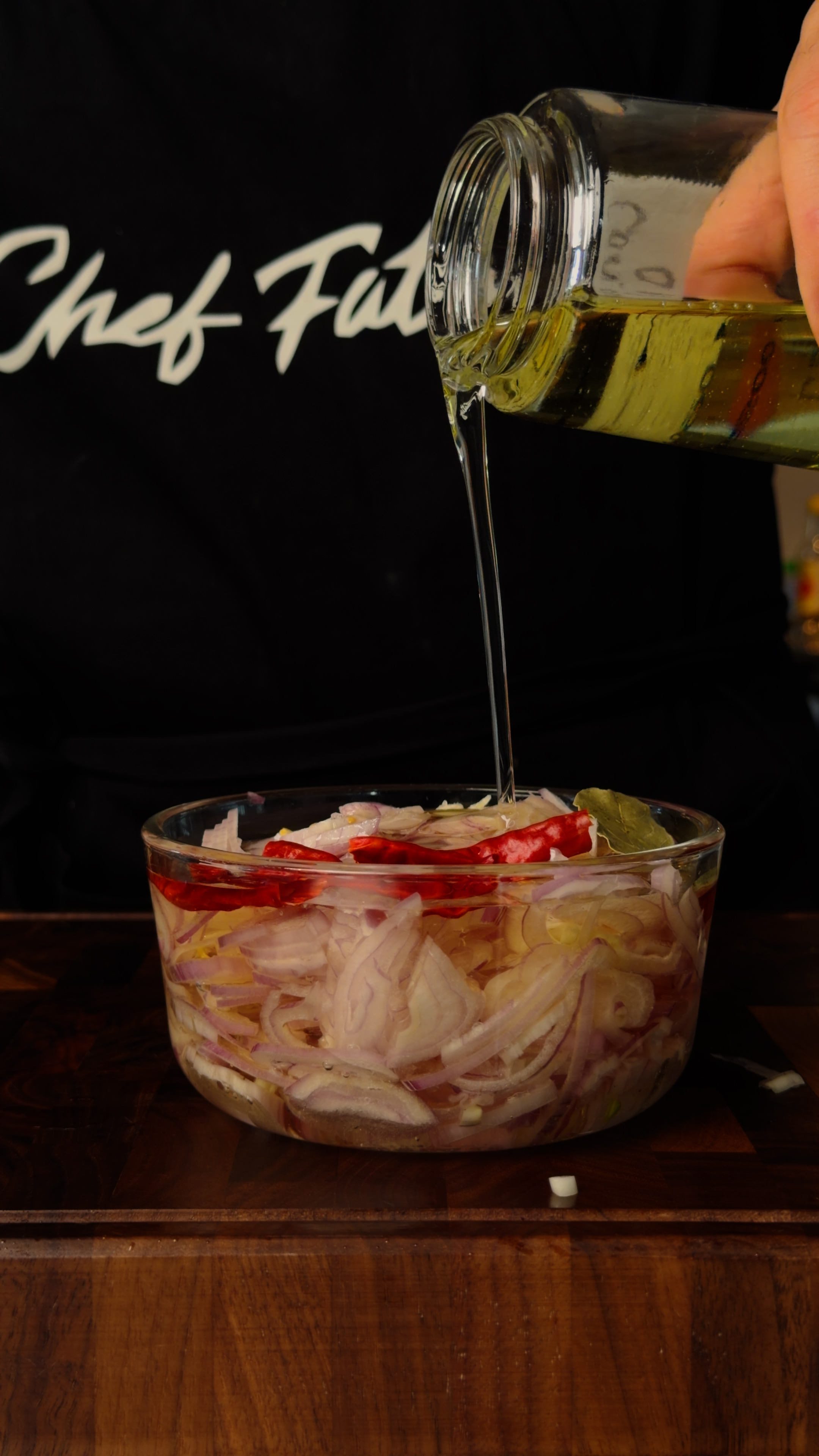 Finished smoky shallot-arbol oil being poured into a mason jar