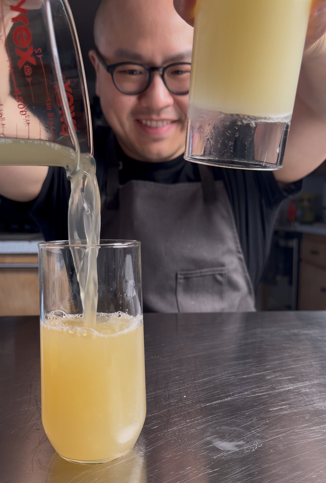 Charles pouring homemade chicken stock into a glass