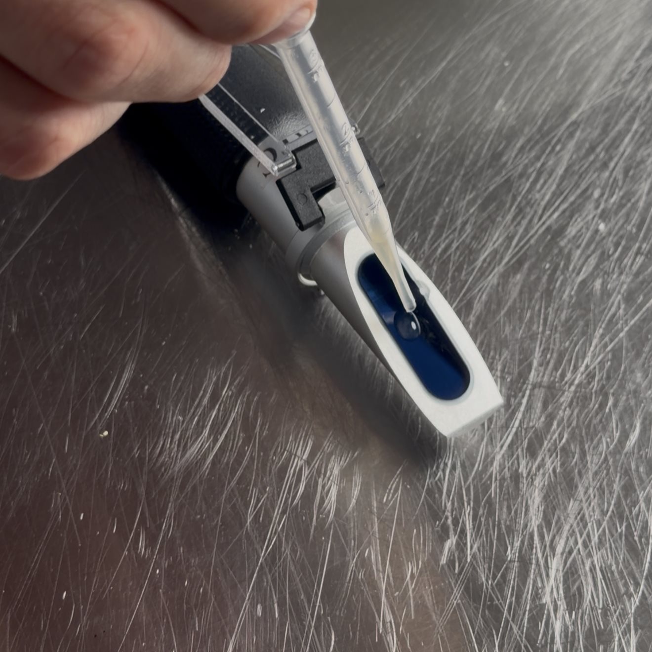Loading a drop of stock onto the refractometer prism