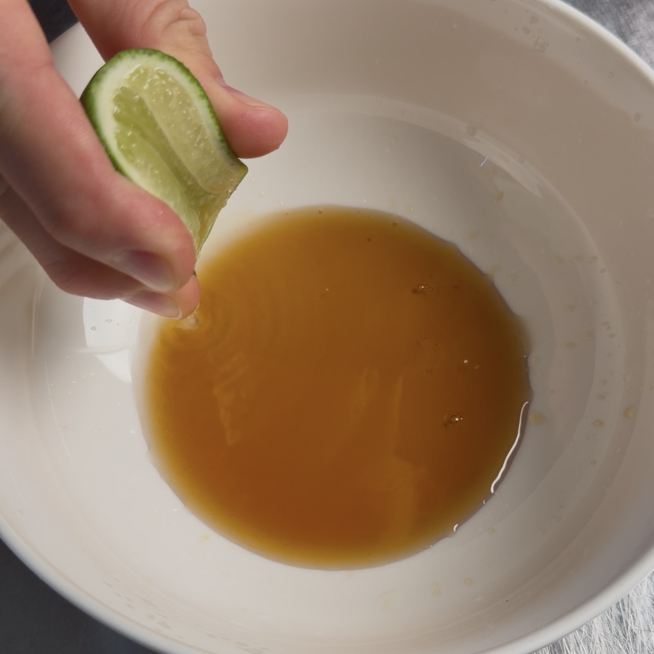 Lime juice being squeezed into fish sauce