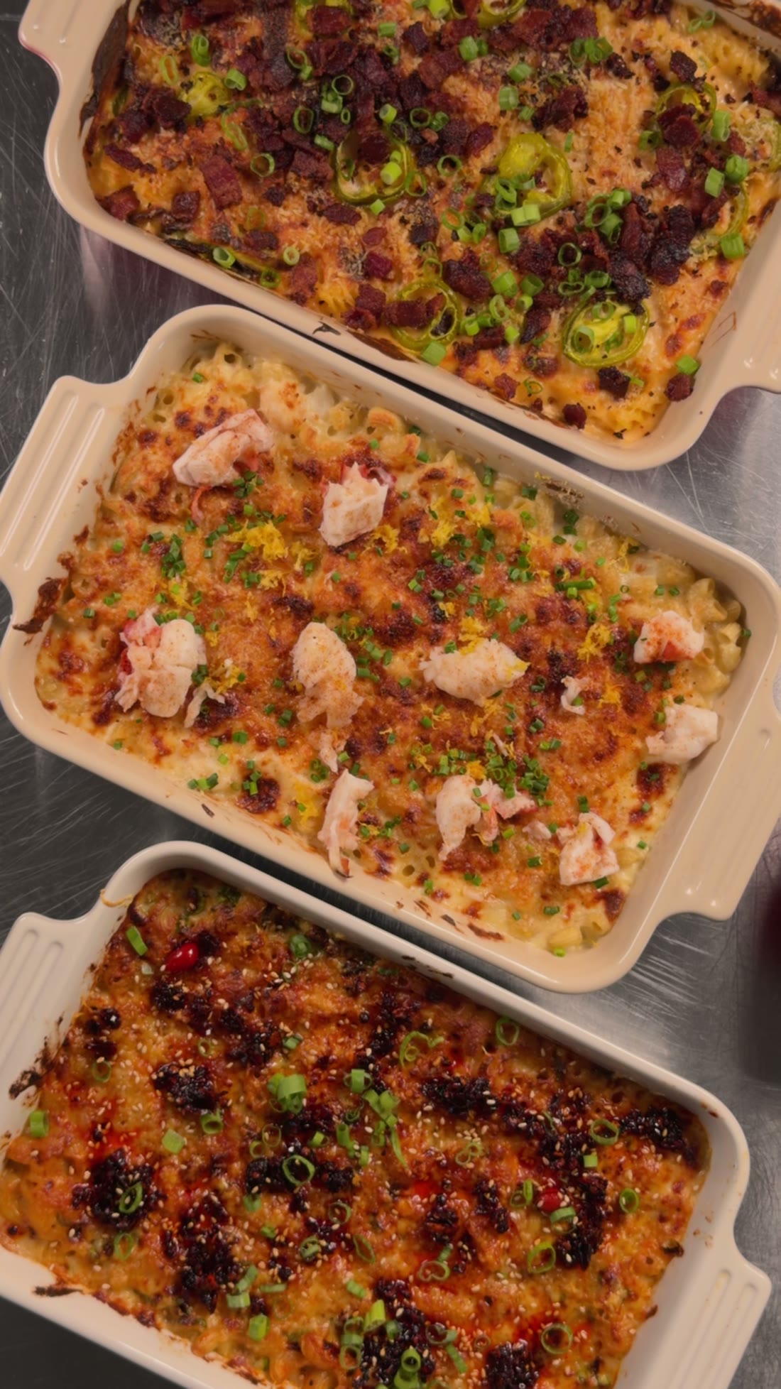 Three baked mac and cheeses side by side: jalapeno popper, lobster, and chili crisp.