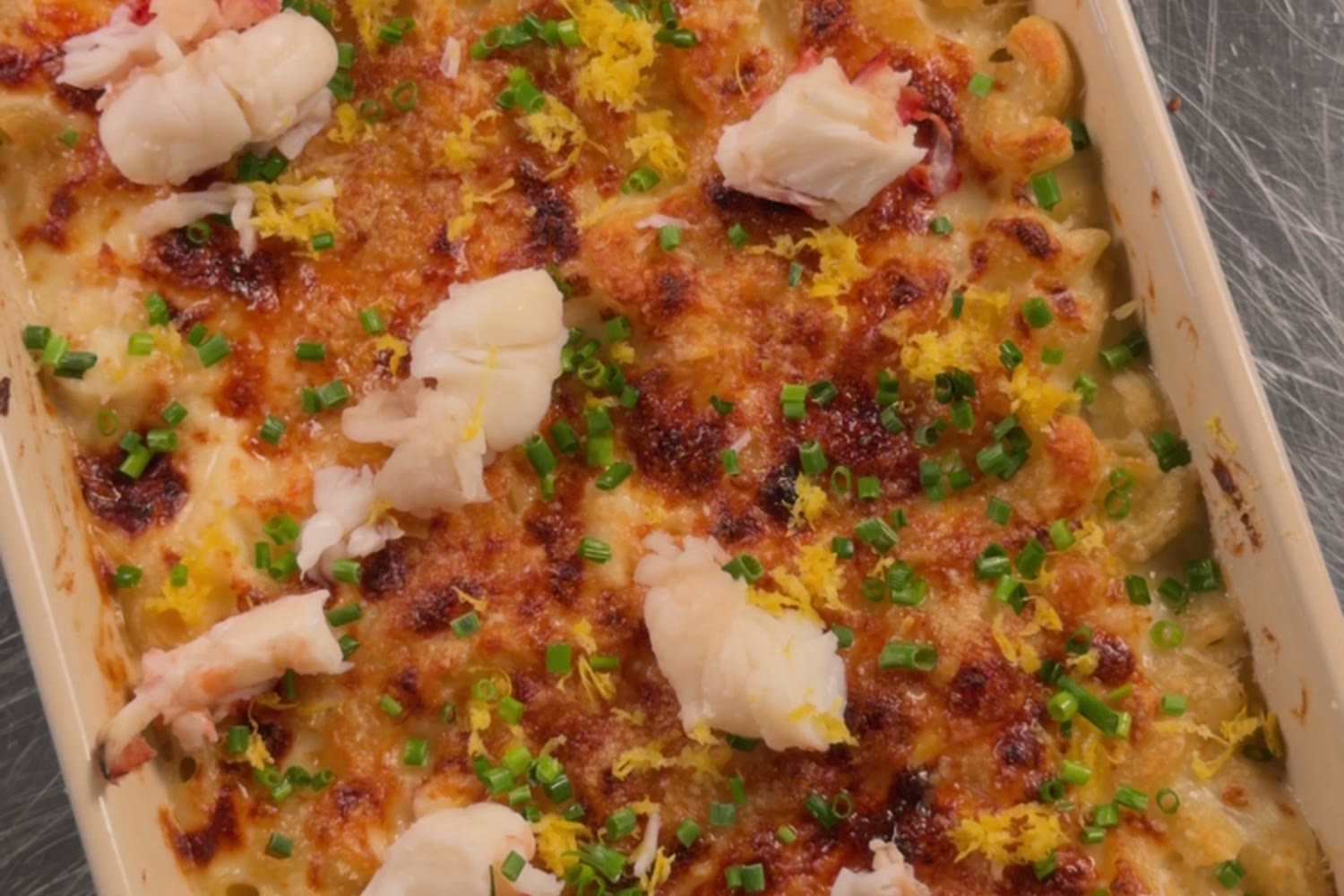 Overhead of the lobster mac topped with lobster chunks, chives, and lemon zest.