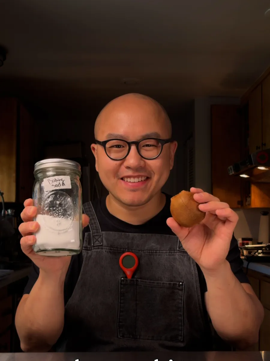 Chef holding a jar of baking soda and a kiwi