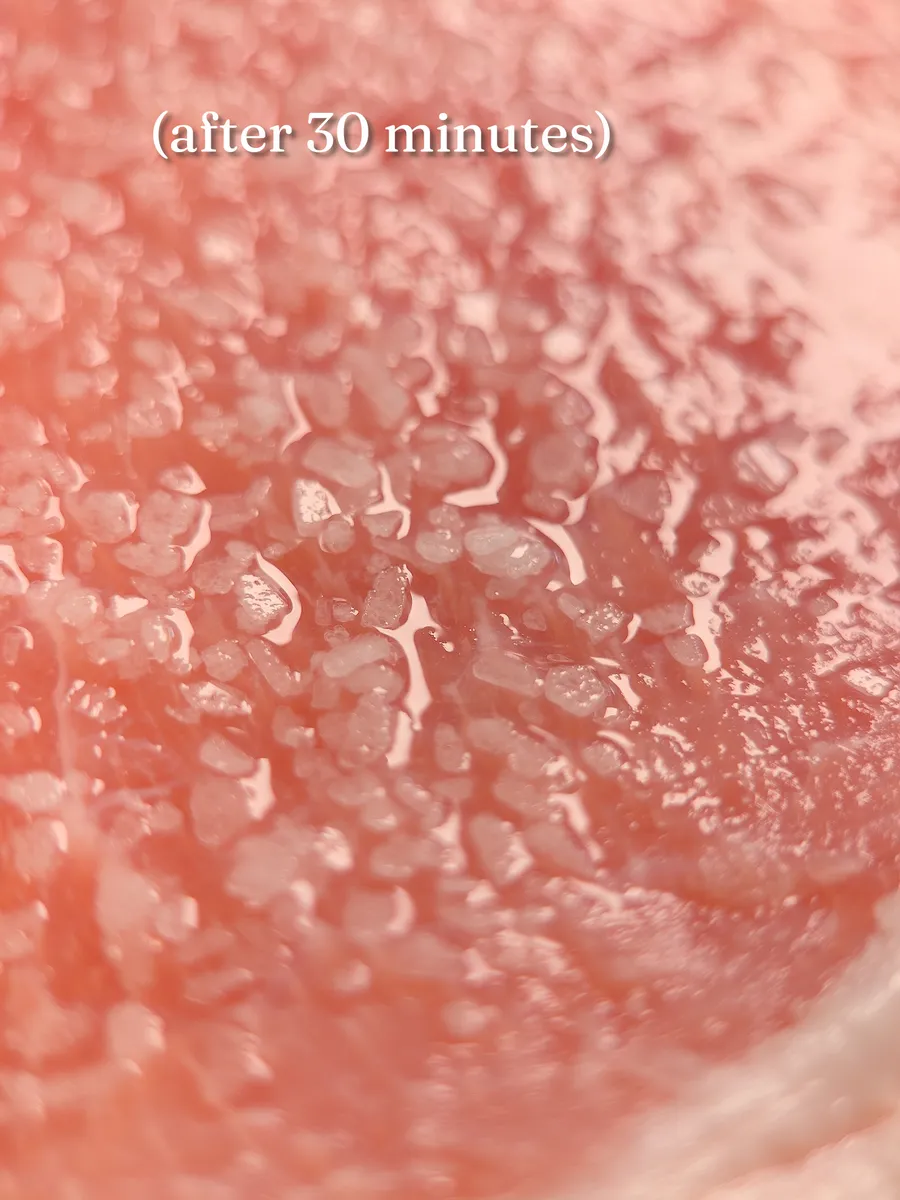 Macro of a salted raw pork surface after 30 minutes, salt crystals dissolving into a wet sheen