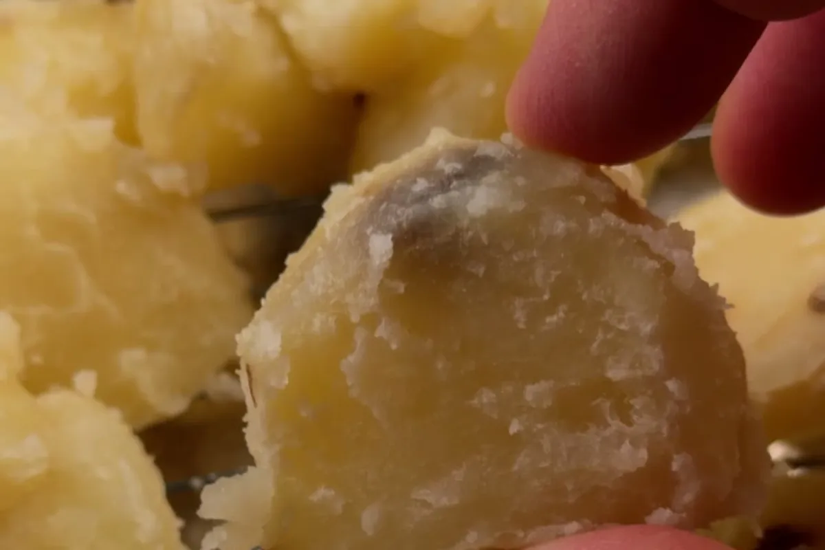 A parboiled potato chunk with a rough, craggy, starchy surface