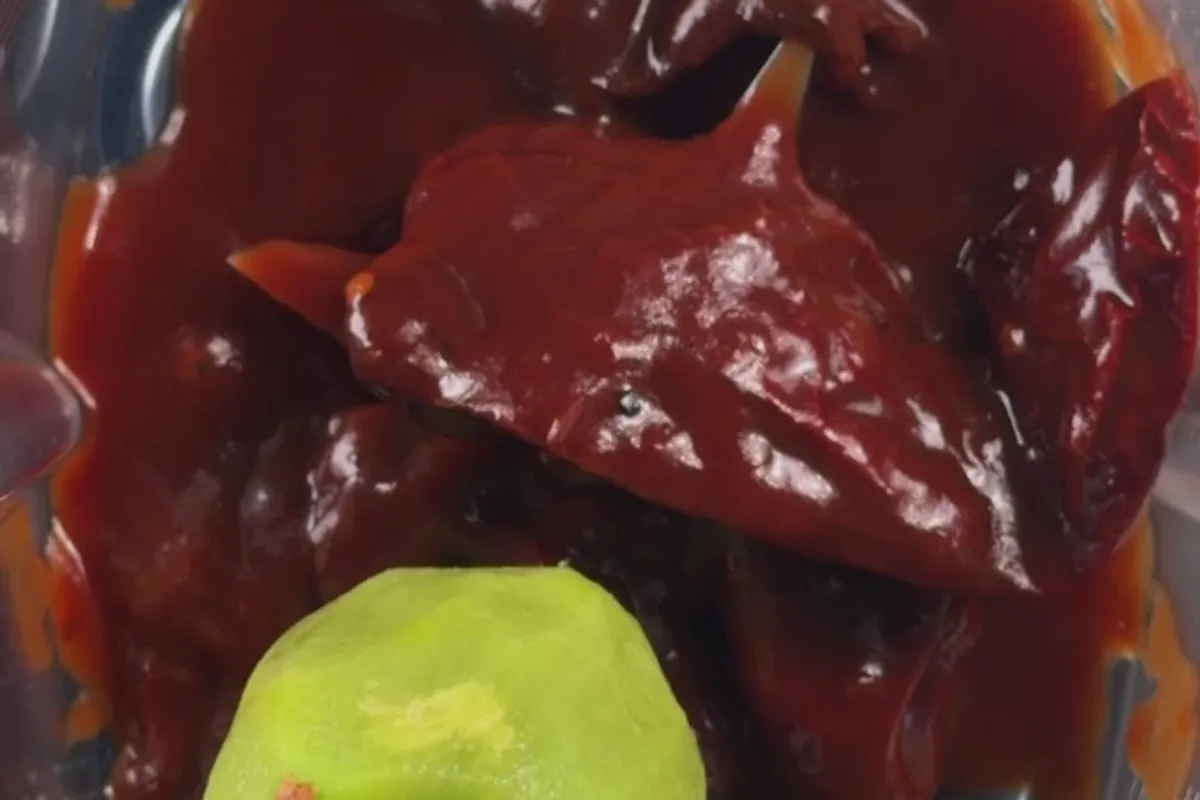 The chipotle marinade in a blender with a peeled green kiwi
