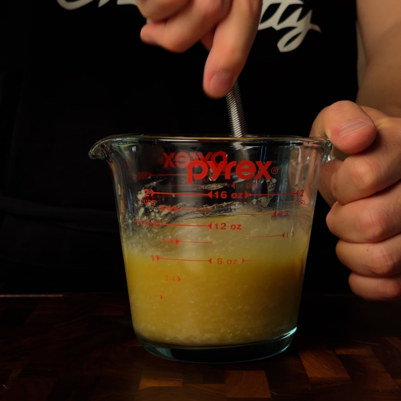 Pyrex measuring cup with maple bacon vinaigrette, Chef Fatty apron in background