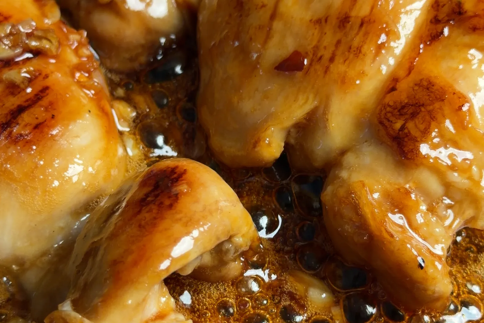 Glazed chicken thighs shining in a glossy caramelized sauce