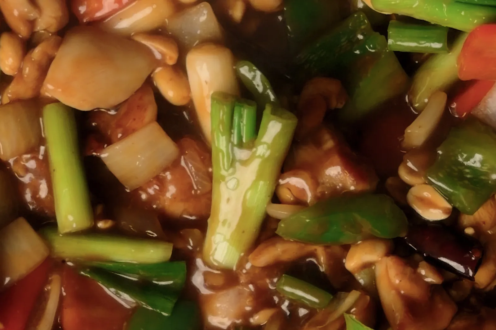 Kung pao chicken stir-fry with peanuts, peppers and scallions in a glossy sauce
