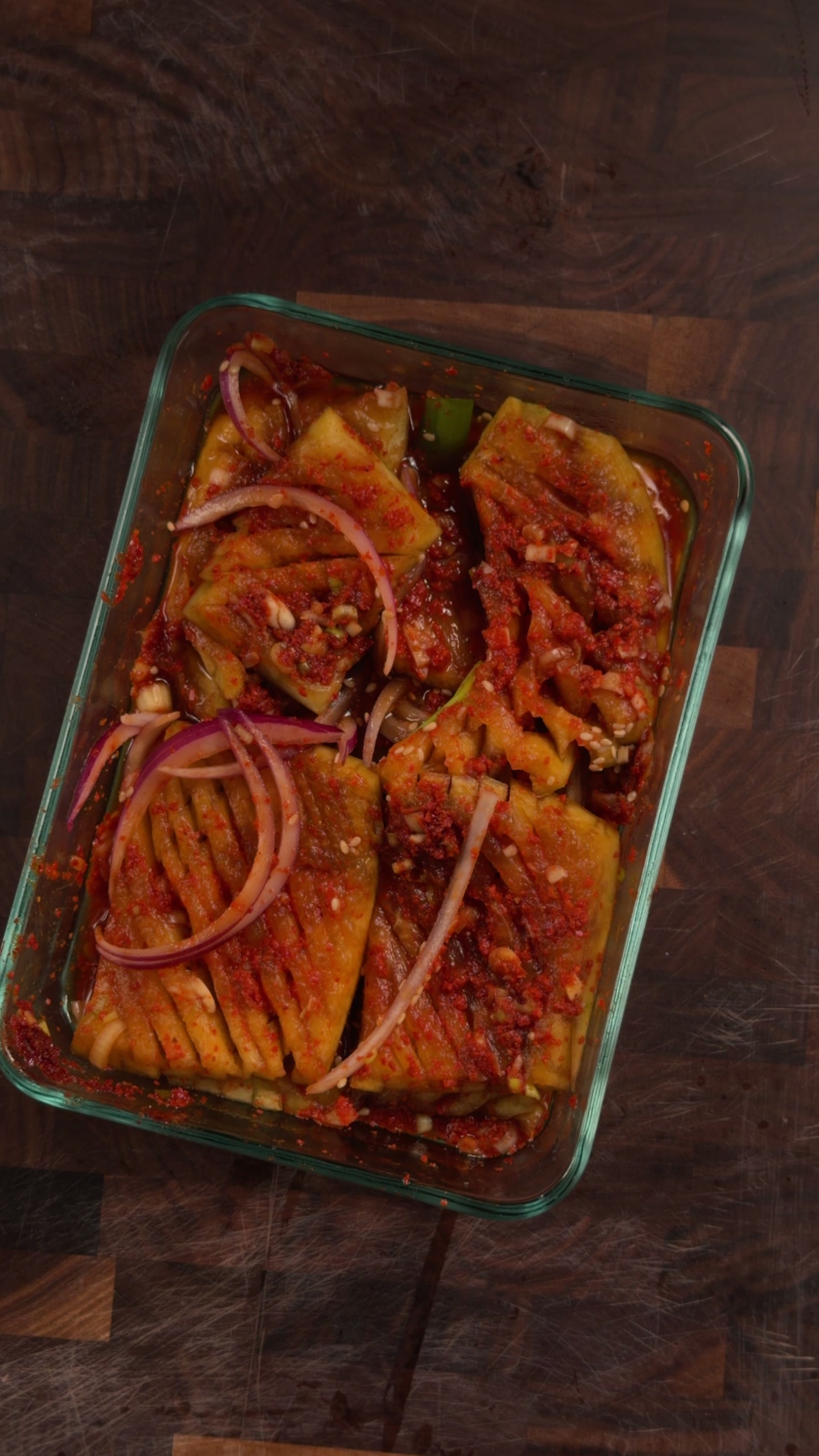 Sliced watermelon rind tossed in a red gochugaru sauce with red onion.