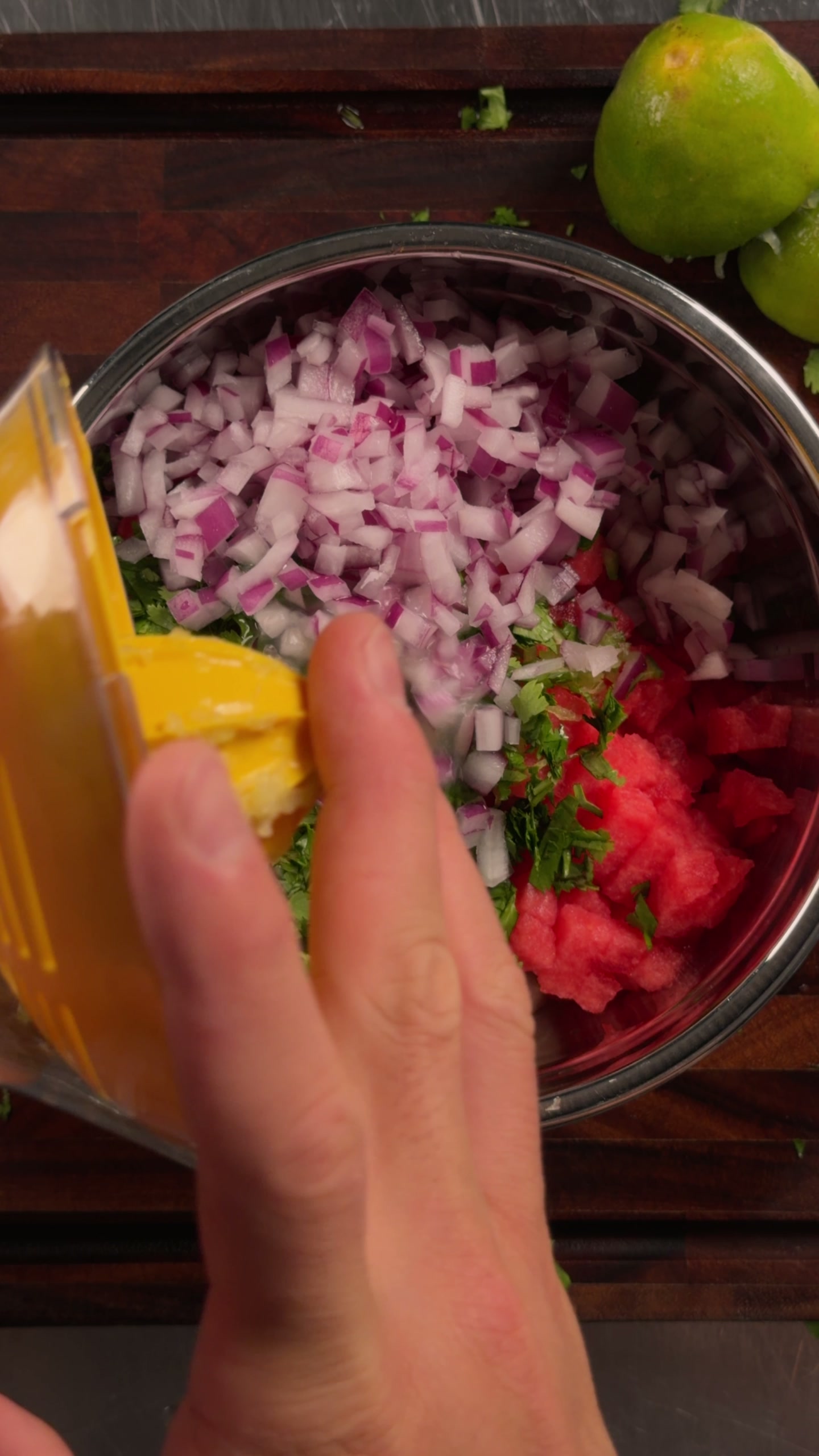 Squeezing fresh lime over the onion and rind.