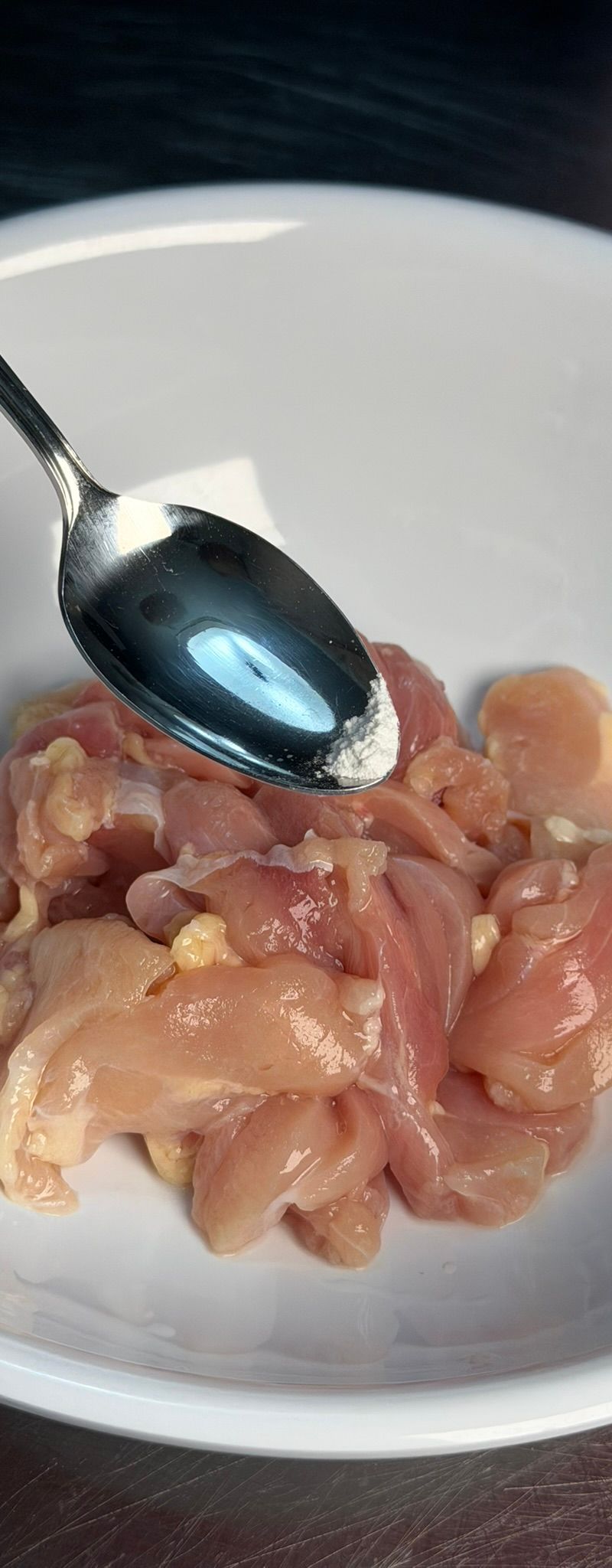 Baking soda being added to chicken