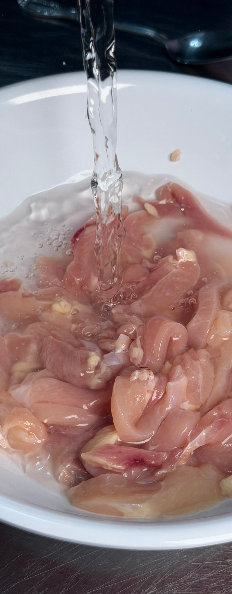 Rinsing chicken under cold water